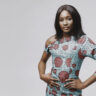 African woman in a studio. White background. Woman in a blue dress.